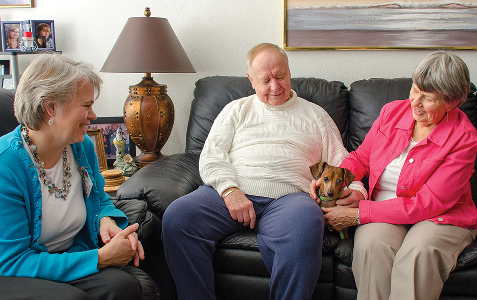 residents on couch with pet dog
