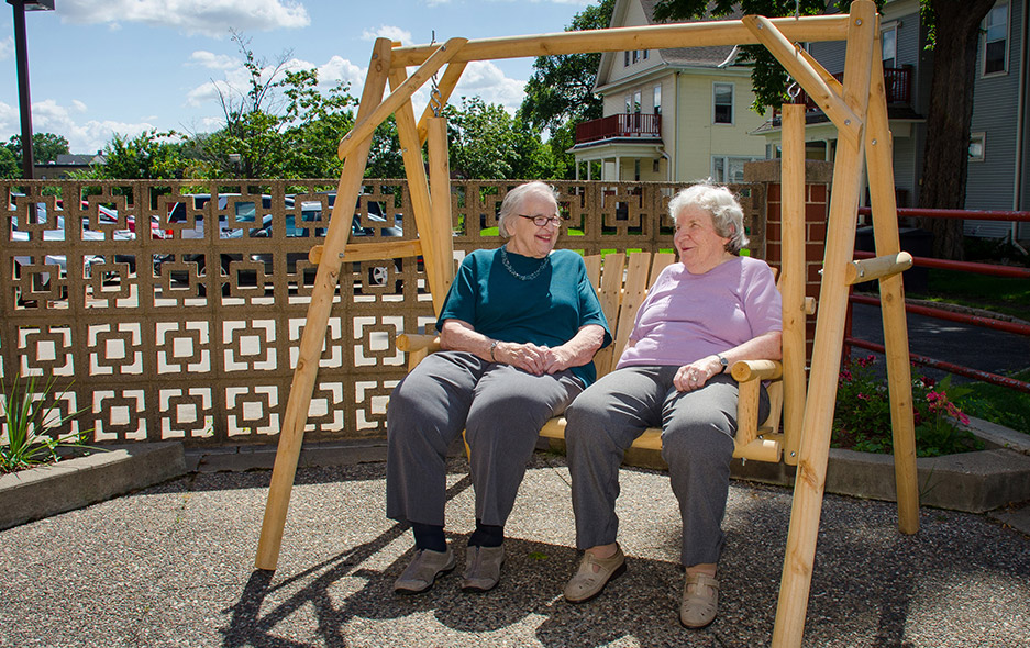 two residents outdoors on swing